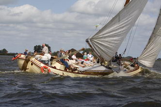 Zeilen met groepen in skûtsjes en polyvalken.